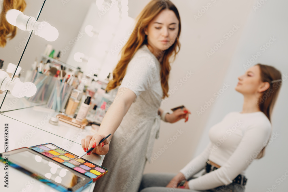 Fototapeta premium Beautiful young woman applying makeup beauty visage brush.