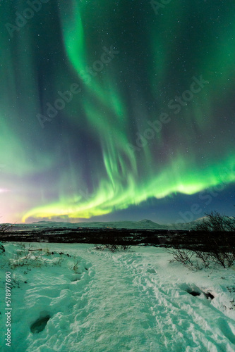 imagen de una aurora boreal iluminando el cielo de Islandia con el paisaje nevado 
