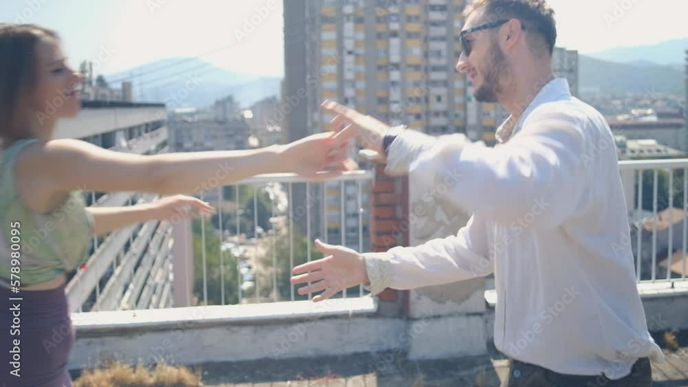 Dancing couple dances on a rooftop of a building Dancing couple dances on a rooftop of a building