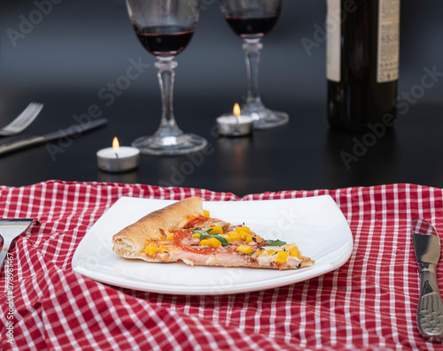 A glass of red wine with pizza on a cutting board. Delicious homemade natural Italian-style whole wheat pizza with vegetables and cheese for a romantic dinner with wine.