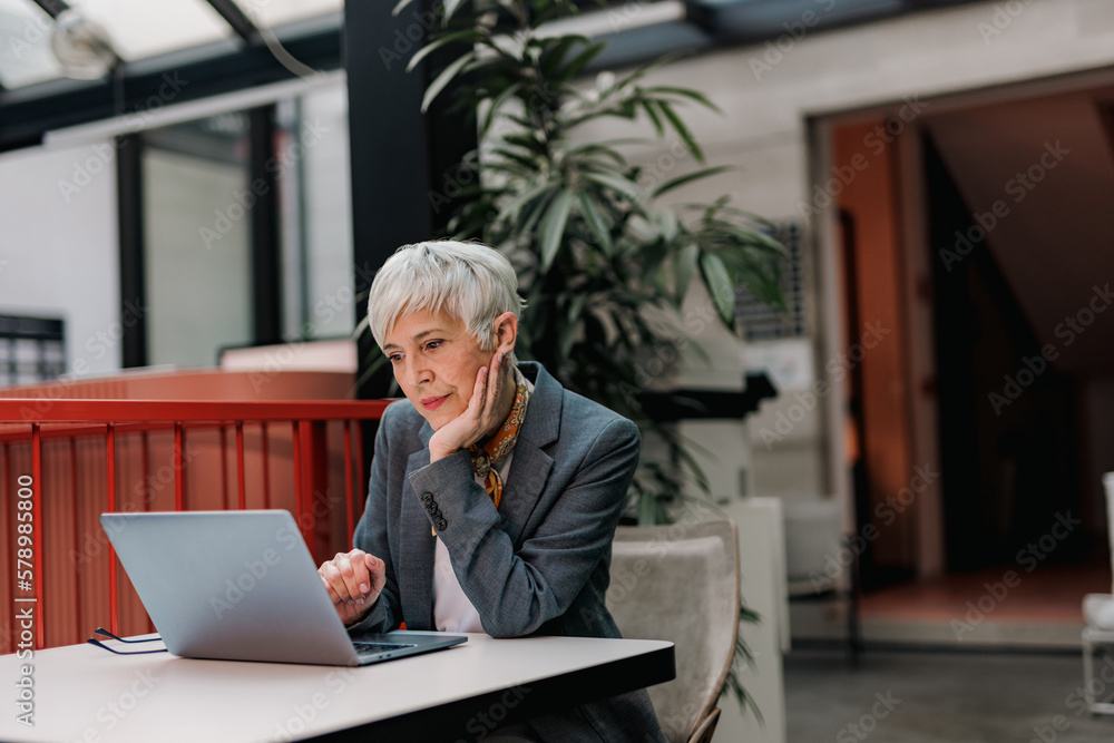 Concentrated businesswoman using a laptop, working over it. Concentrated businesswoman using a laptop, working over it.