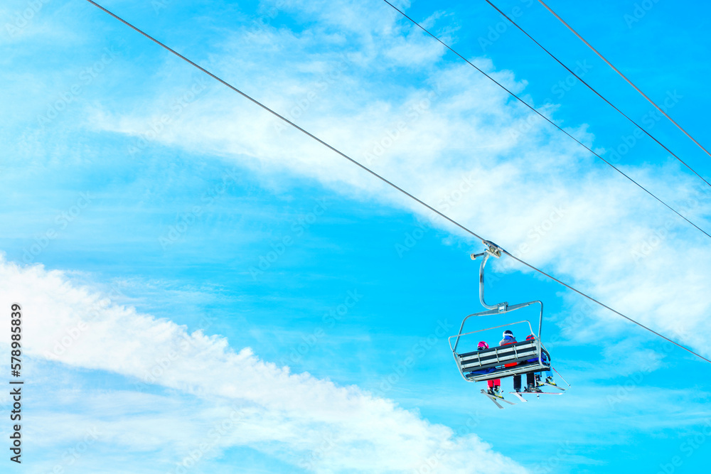 Ski Lift with Skiers against Blue Sky on a Sunny Day