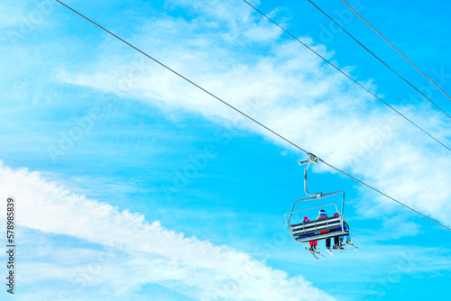 Ski Lift with Skiers against Blue Sky on a Sunny Day