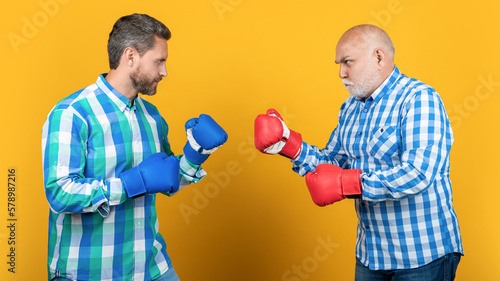 two generation men fighting isolated on yellow. generation men fighting in studio photo