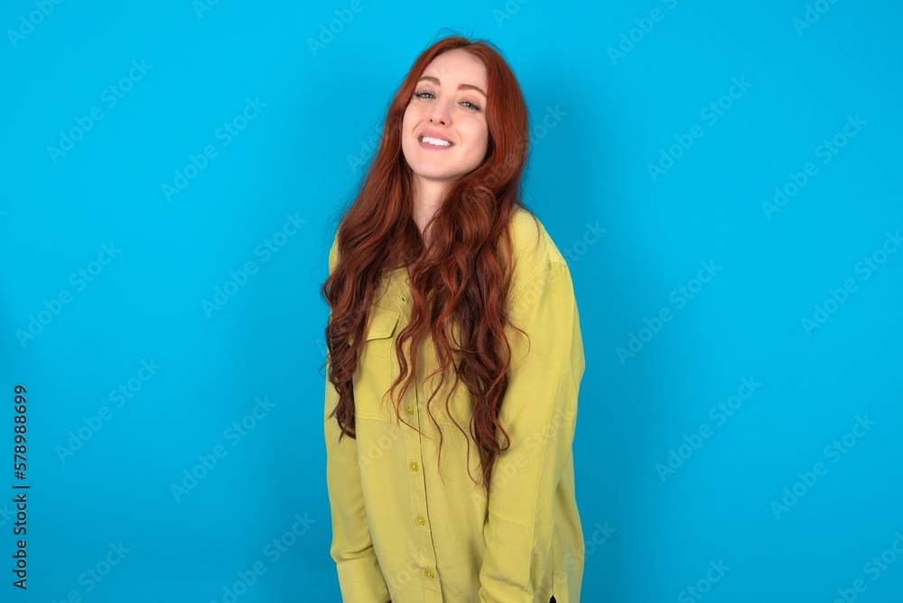 young woman wearing green sweater over blue background very happy and excited about new plans. young woman wearing green sweater over blue background very happy and excited about new plans.
