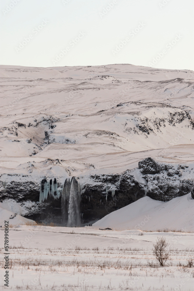 Fototapeta premium imagen detalle montaña nevada con una cascada y el cielo azul