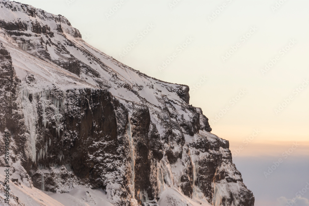 imagen detalle montaña oscura con nieve y el cielo con las primeras luces del día 