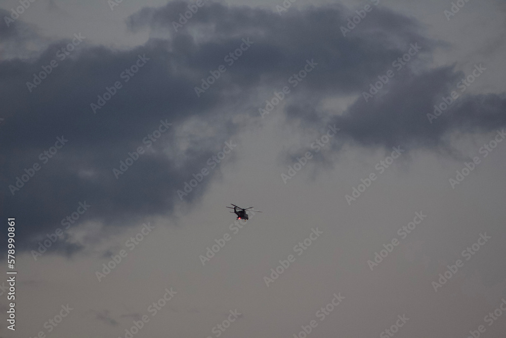 Rainy Clouds. A helicopter in a rainy cloudy sky covering the sun. Clouds Covering Sky.