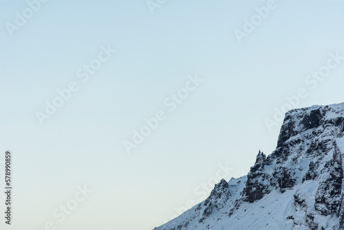 imagen detalle cima de una montaña nevada con el cielo azul de fondo 