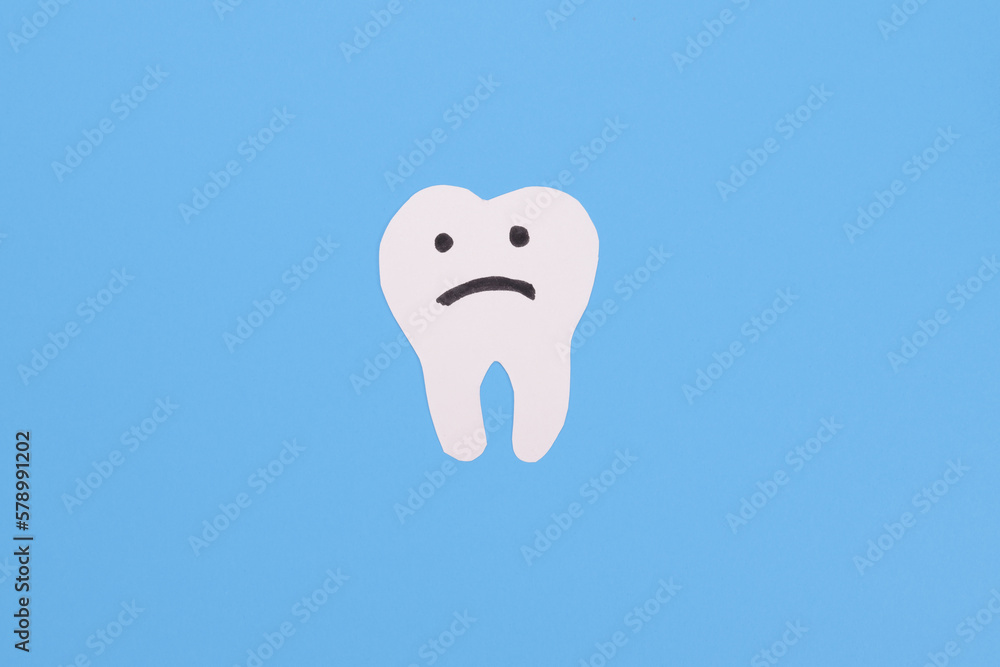 Upset paper tooth, concept of dental problems, caries, gum inflammation, mouth infections Upset paper tooth, concept of dental problems, caries, gum inflammation, mouth infections