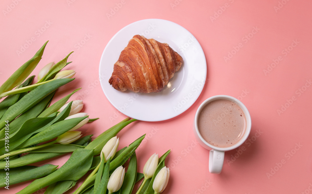 white tulips and croissant on a white plate on a pink background with space for text white tulips and croissant on a white plate on a pink background with space for text