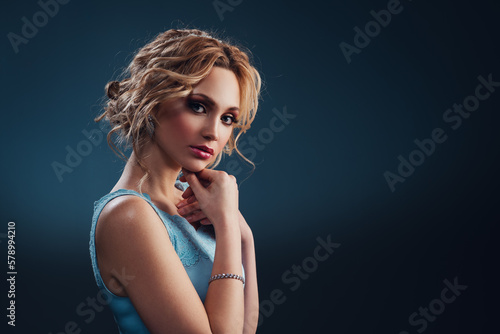 Young elegant blond woman in blue dress fashion portrait