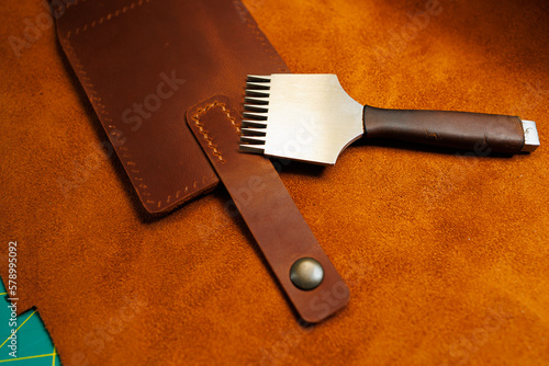 The process of production of leather goods. Materials and tools for leather production. Beautiful brown leather products and tools for needlework.