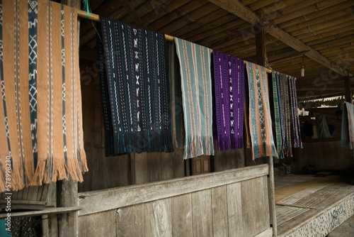 The traditional Bena Village on Flores, in focus traditional sarongs hanging in front of a hut. photo