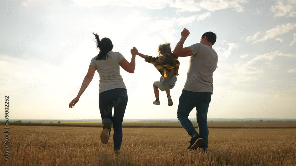 happy family. father mother and daughter together run throw up in park at sunset silhouette. people in park. happy family and little baby child summer. kid dream concept. children fun run happy family. father mother and daughter together run throw up in park at sunset silhouette. people in park. happy family and little baby child summer. kid dream concept. children fun run