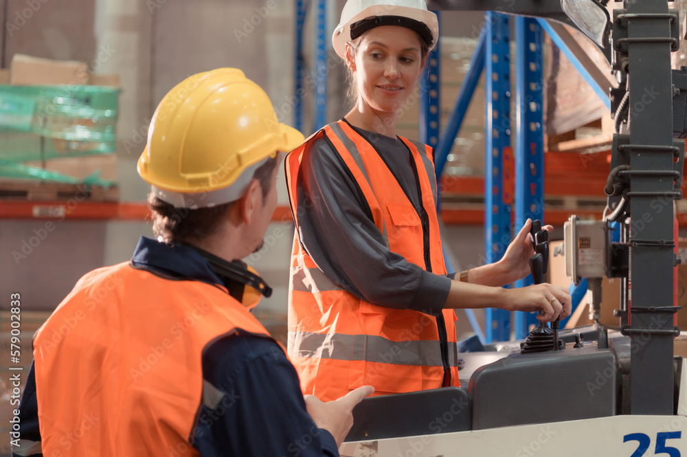 Manager with foreman discuss about the equipment used to move goods in the warehouse. Manager with foreman discuss about the equipment used to move goods in the warehouse.