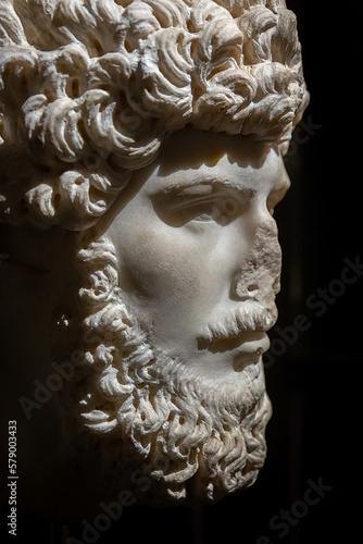 Marble Head of Roman Emperor Lucius Verus, Roman sculpture portrait. Close up, vertical shot, black background. Istanbul, Turkey (Turkiye). History and art concept photo