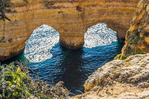 Heart shape made by rocks and plants at Marinha Beach in Algarve, Portugal
