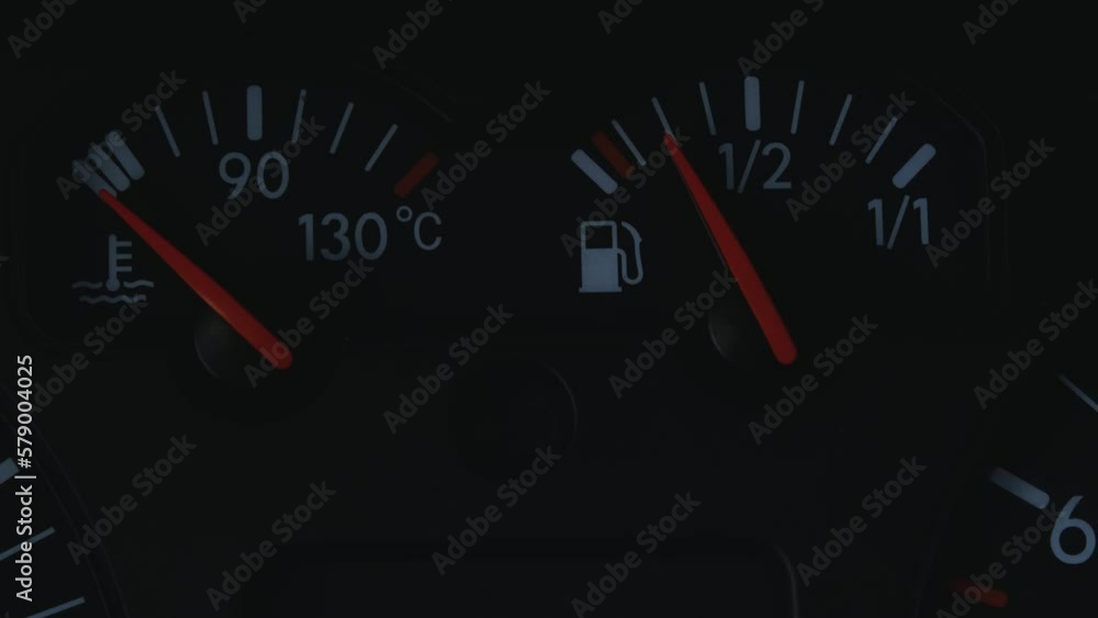 Dashboard of old 2000s car close-up. The tank with gasoline is almost empty and the engine temperature is low. The red arrows point to the white measurement scale inside the car. Dashboard of old 2000s car close-up. The tank with gasoline is almost empty and the engine temperature is low. The red arrows point to the white measurement scale inside the car.