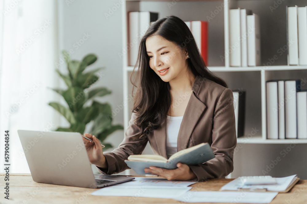 Asian businesswoman in formal suit in office happy and cheerful during using smartphone and working Asian businesswoman in formal suit in office happy and cheerful during using smartphone and working