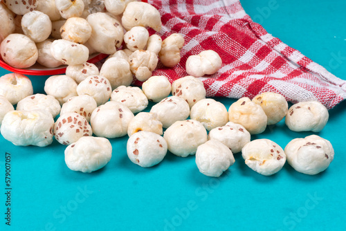 Organic Crispy Lotus pops Seeds or Phool Makhana served in a wooden bowl on background.