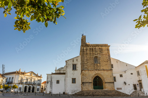 Downtown of Faro with Se Cathedral in the morning with orange tree in the foreground, Portugal