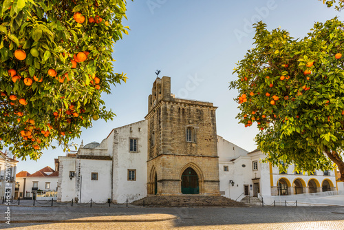 Downtown of Faro with Se Cathedral in the morning with orange tree in the foreground, Portugal