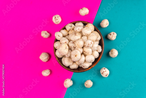 Organic Crispy Lotus pops Seeds or Phool Makhana served in a wooden bowl on background.