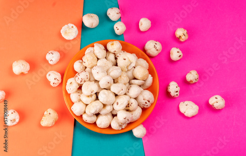 Organic Crispy Lotus pops Seeds or Phool Makhana served in a wooden bowl on background.
