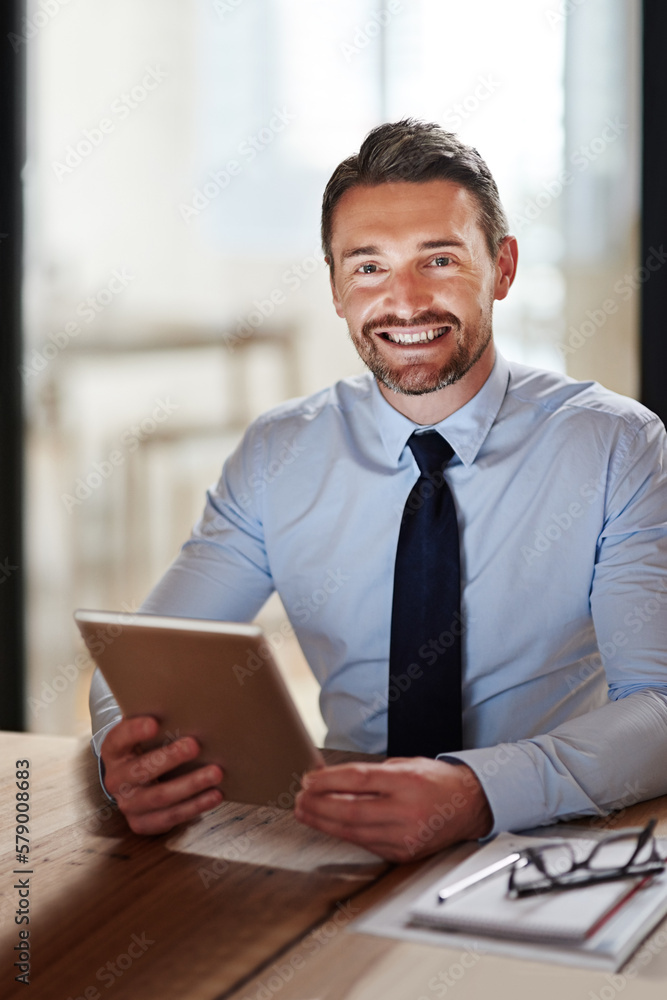 Modern tools for a modern executive. Portrait of a smiling businessman using a digital tablet in an office. Modern tools for a modern executive. Portrait of a smiling businessman using a digital tablet in an office.