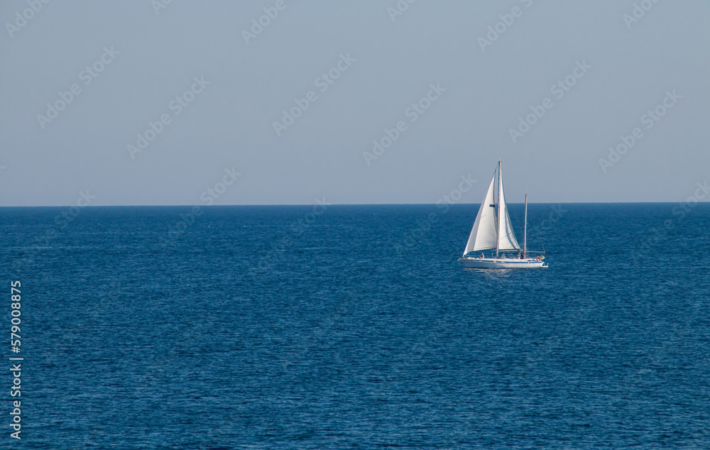 Velero navegando en el horizonte en Gallipoli, Italia. Yate con las velas desplegadas navengando en las aguas turquesas del mar Jónico. - obrazy, fototapety, plakaty 