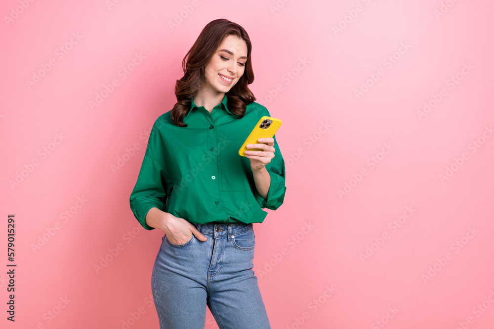 Portrait of cheerful charming lady use smart phone chatting empty space isolated on pink color background Portrait of cheerful charming lady use smart phone chatting empty space isolated on pink color background