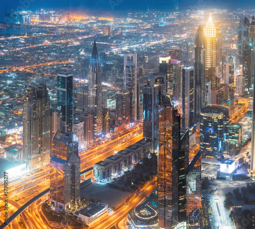 Aerial View Of Urban Background Of Illuminated Cityscape With Skyscrapers In Dubai. Street Night Traffic In Dudai Skyline. Moving through modern city street with illuminated. UAE, United Arab Emirates