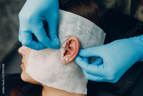 Obraz na płótnie Young woman doing piercing at beauty studio salon w salonie