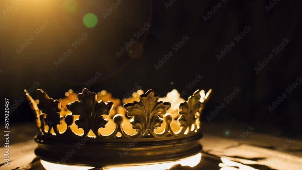 The crown on a black background is illuminated by a golden beam. Low