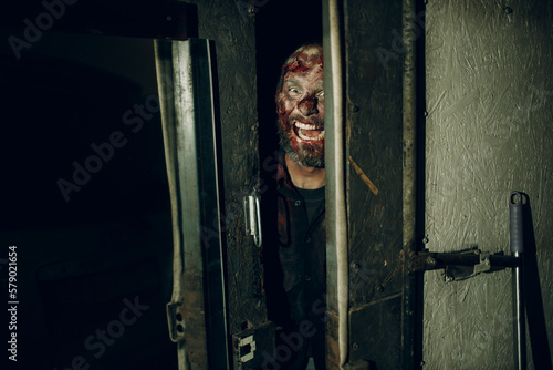 Zombie looking open door halloween concept. Make up skin and blood face