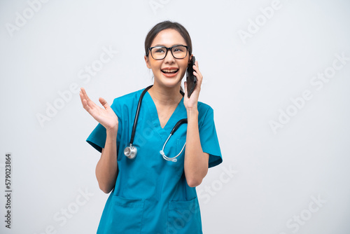 Portrait of Asian female doctor with stethoscope talking on mobile phone isolated on white background.