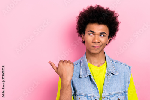 Portrait of minded young person look interested indicate thumb finger empty space isolated on pink color background