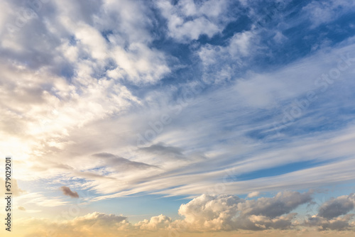 Panorama of a blue sunset sky with light clouds as a background or texture