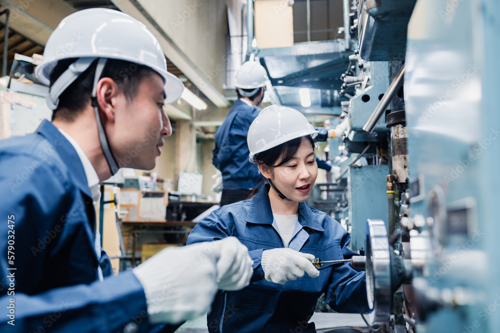 工場で作業を教えてもらう外国人労働者 工場で作業を教えてもらう外国人労働者