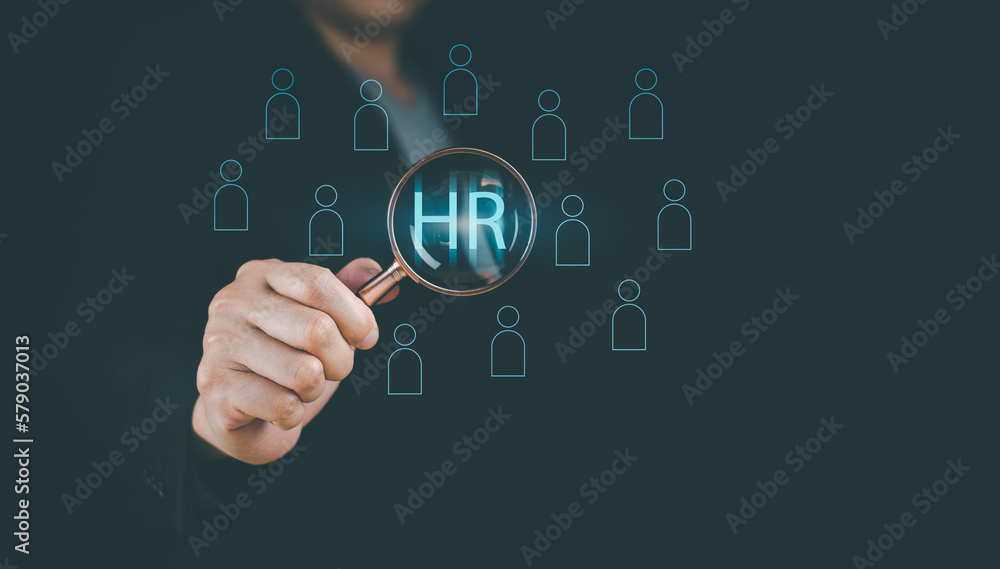 Businessman showing human resources virtual icon or HRM, magnifying glass focus on manager icon, one of employee icons for leadership service, leading organization in recruiting and prospecting. Businessman showing human resources virtual icon or HRM, magnifying glass focus on manager icon, one of employee icons for leadership service, leading organization in recruiting and prospecting.