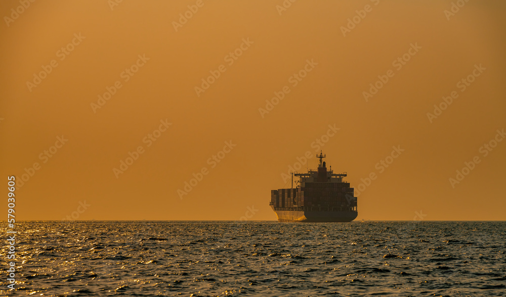 Silhouette cargo shipping transportation logistic commerce industry loading export on open sea with twilight sky background