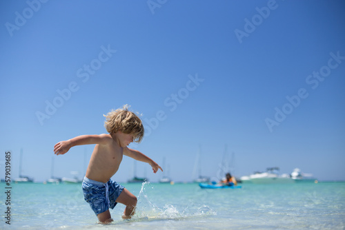 Young boy playing at beach photo