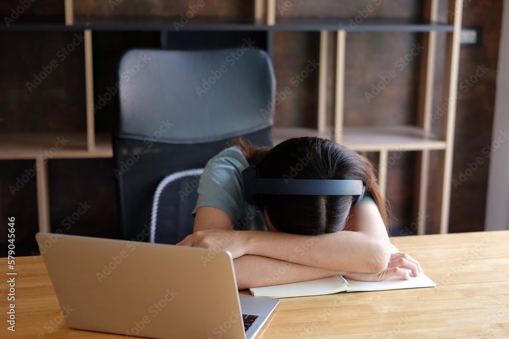 © Sucharat - Tired Asian student girl lying on table in front of laptop, sleeping, taking break during online learning. Female freelancer napping at home office, feeling lazy to work remotely. Selective focus © Sucharat - Tired Asian student girl lying on table in front of laptop, sleeping, taking break during online learning. Female freelancer napping at home office, feeling lazy to work remotely. Selective focus