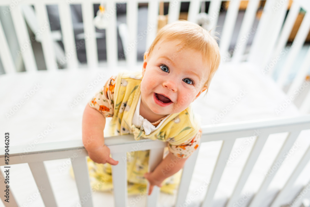 Happy aussie baby smiling up at camera from cot in bedroom Happy aussie baby smiling up at camera from cot in bedroom