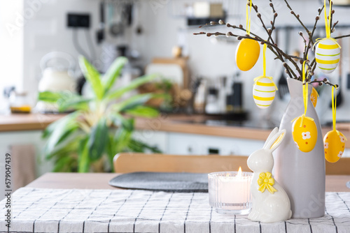 Photography Easter decoration of colorful eggs in a basket and a rabbit on the kitchen table in a rustic style