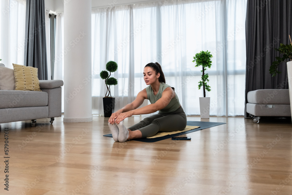 Strong sweaty and beautiful athletic fitness girl in sportswear doing exercises and home workout in her bright and spacious living room with minimalist interior. Self love confident woman practice Strong sweaty and beautiful athletic fitness girl in sportswear doing exercises and home workout in her bright and spacious living room with minimalist interior. Self love confident woman practice