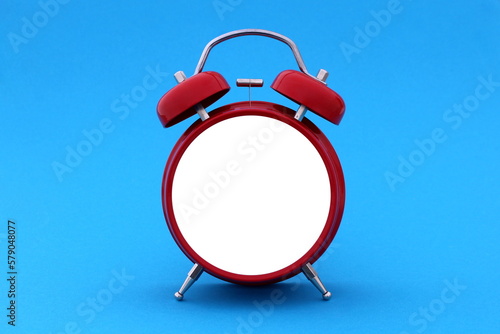 On a blue background there is an alarm clock without a face.