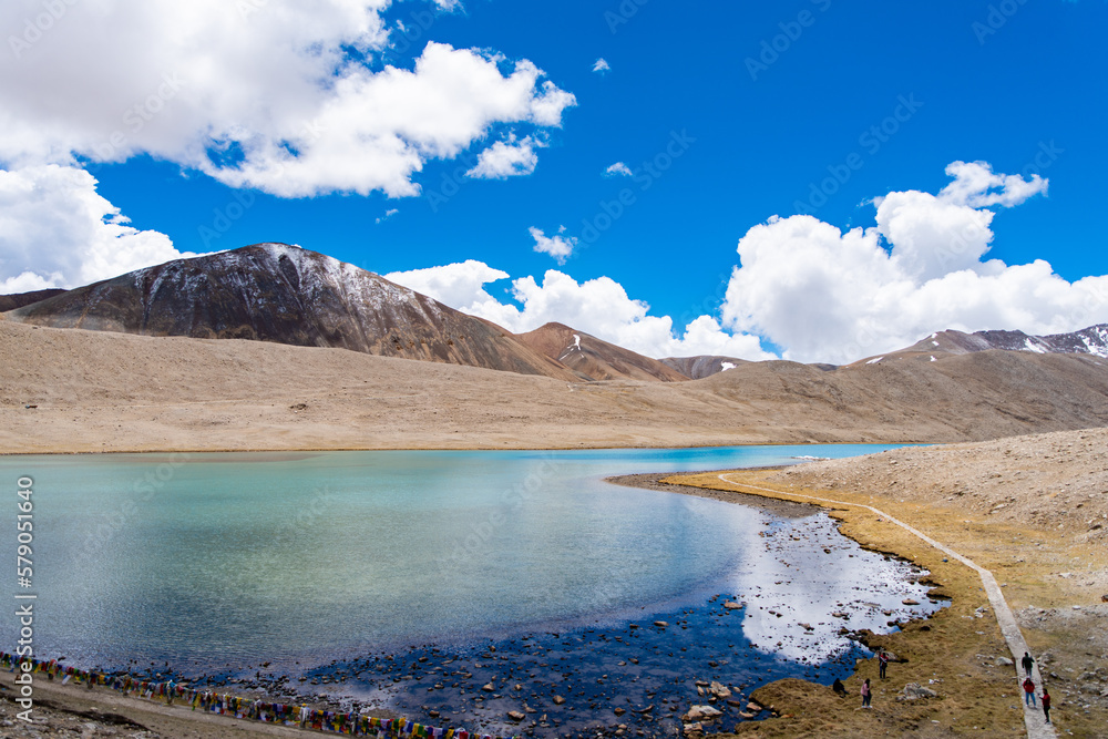 Gurudongmar Lake in the foreground with arid area landscape and snow peaks in the back ground Gurudongmar Lake in the foreground with arid area landscape and snow peaks in the back ground