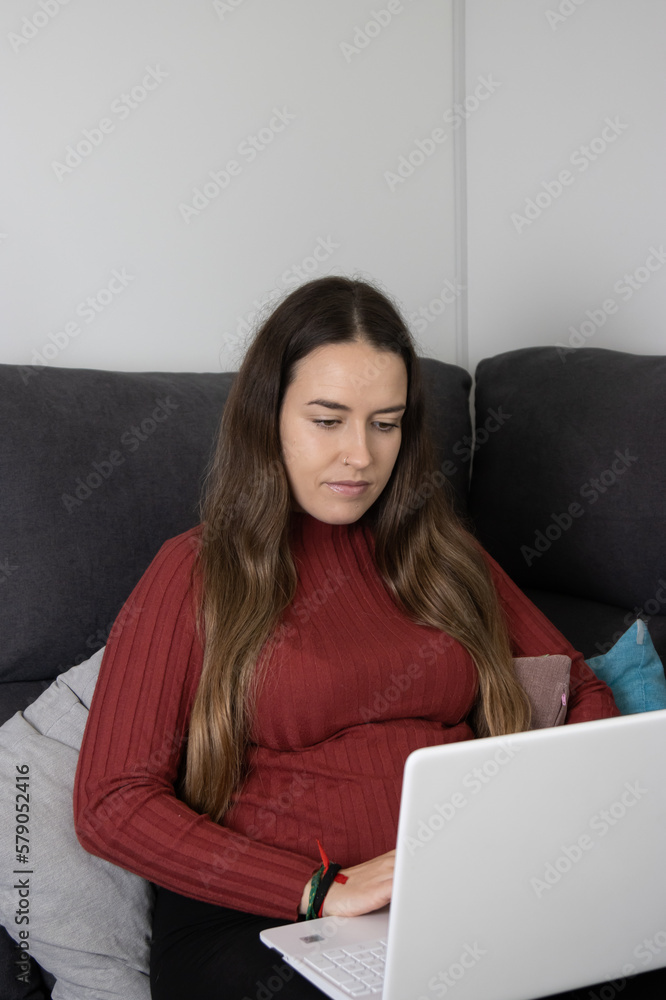girl sitting on the sofa working with the computer girl sitting on the sofa working with the computer